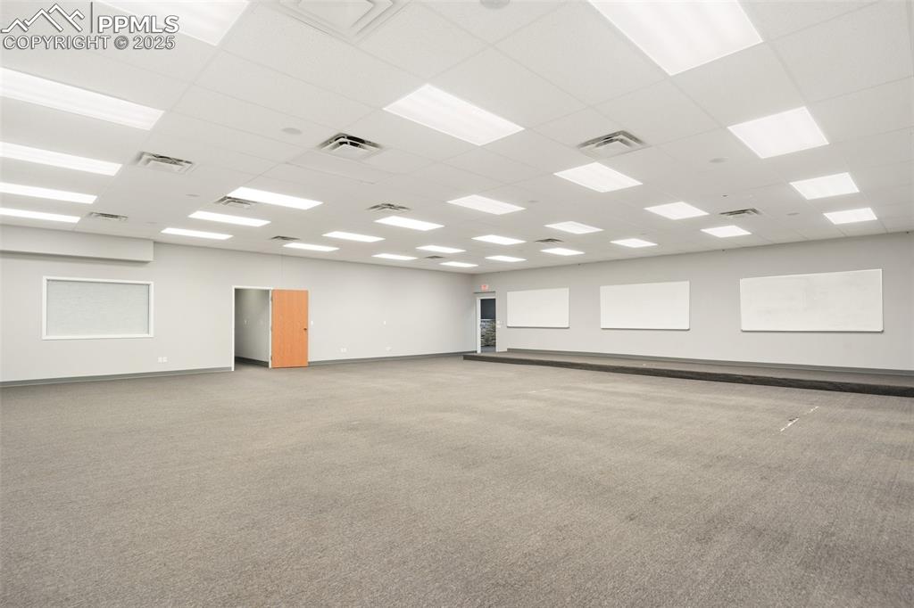 Image 22 of 26: Carpeted empty room with a drop ceiling