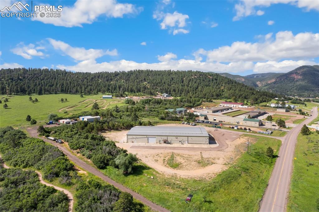 Image 3 of 26: Drone / aerial view of a heavily wooded area and mountains