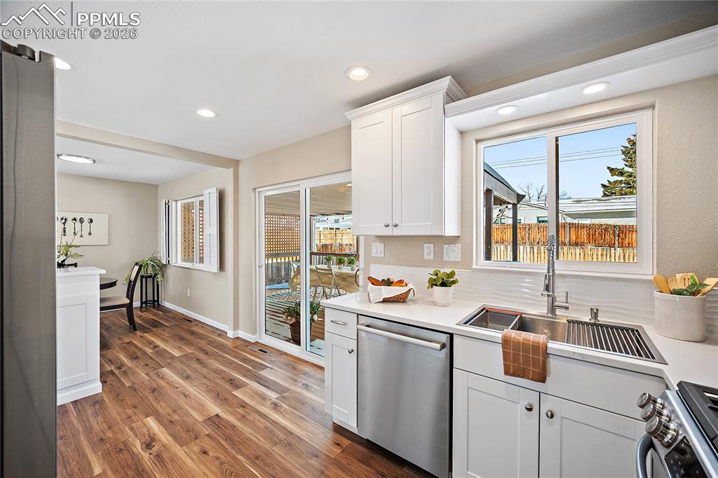 Image 15 of 45: Kitchen walks out to covered deck and fully fenced back yard. 