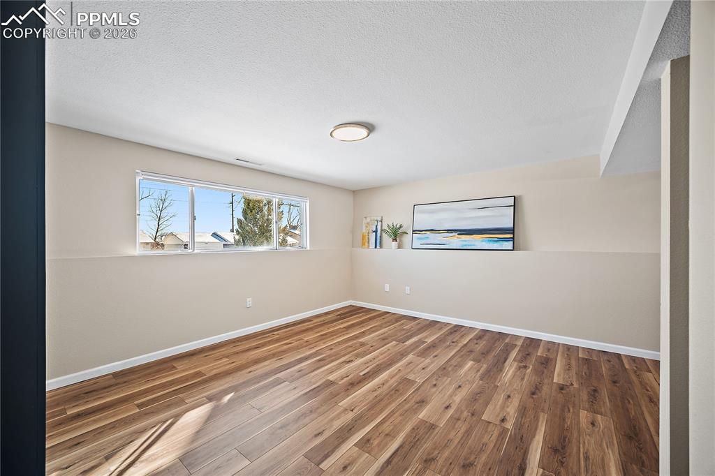 Image 26 of 45: Lower level family room. New flooring, paint and lighting. 