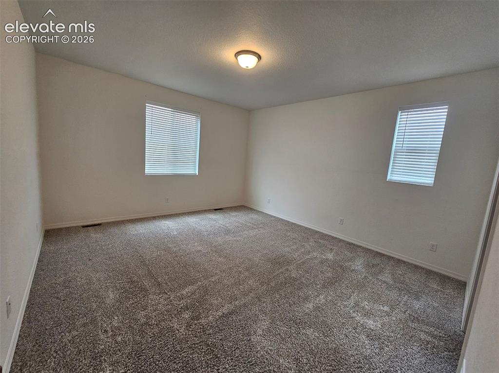 Image 14 of 25: Neutral-toned walls with textured carpeting