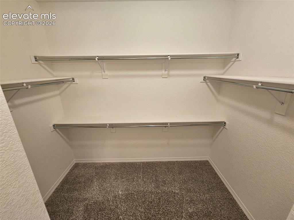 Image 17 of 25: Built-in shelving with chrome hanging rods, ample storage capacity, texture
