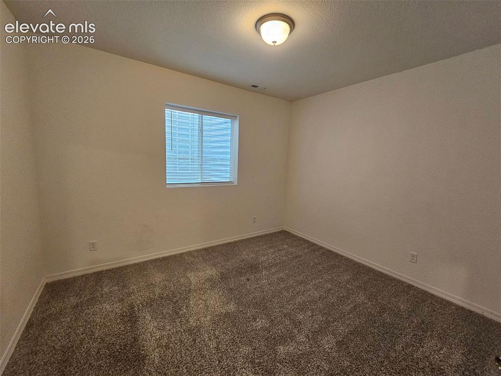 Image 18 of 25: Neutral wall color, wall-to-wall carpeting, and a window with blinds