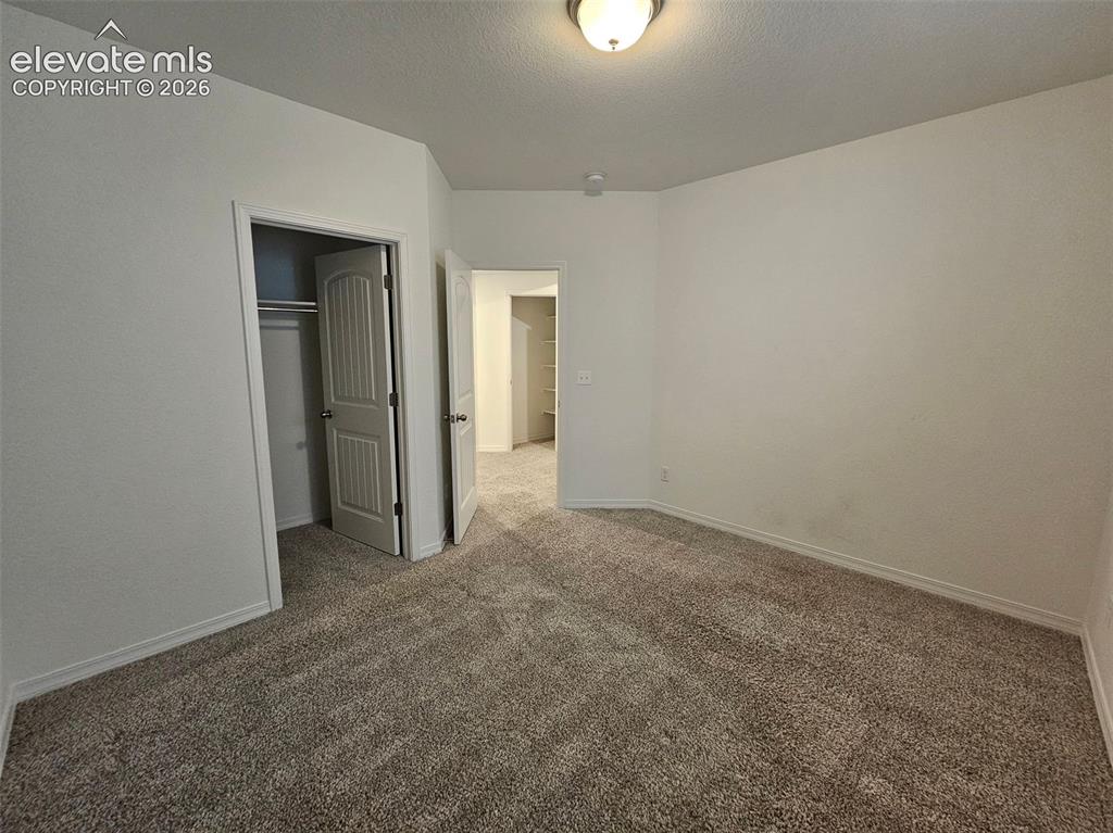 Image 19 of 25: Neutral wall paint, carpet flooring, a flush-mount ceiling light fixture, a