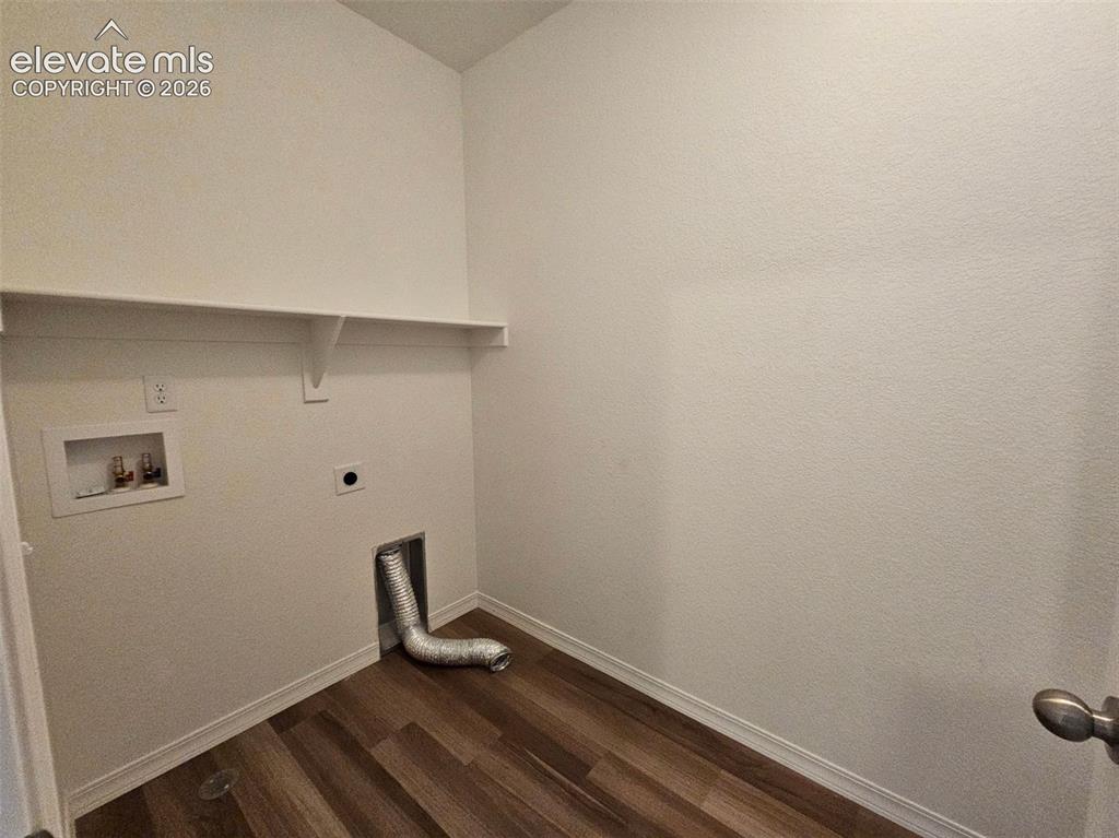 Image 8 of 25: Utility area featuring wood-finish flooring, a wall-mounted shelf, and appl