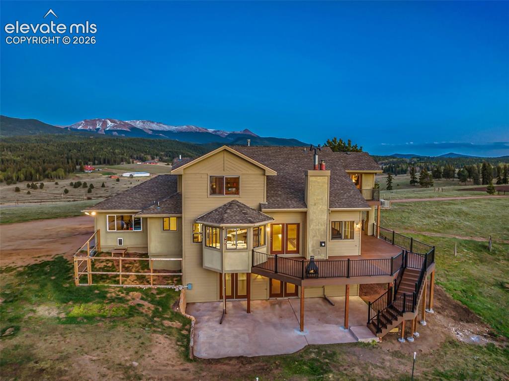 Image 2 of 50: Multilevel residence featuring a spacious rear deck, ground-level patio, an