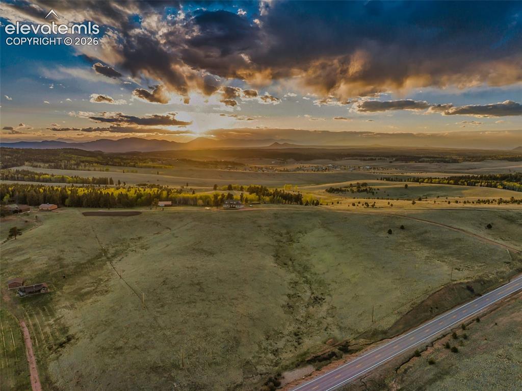 Image 4 of 50: Expansive rural landscape featuring rolling green hills and distant mountai