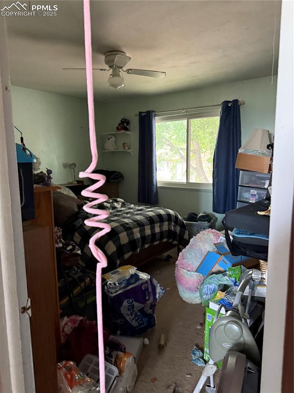 Image 6 of 10: Bedroom featuring unfinished concrete flooring and a ceiling fan