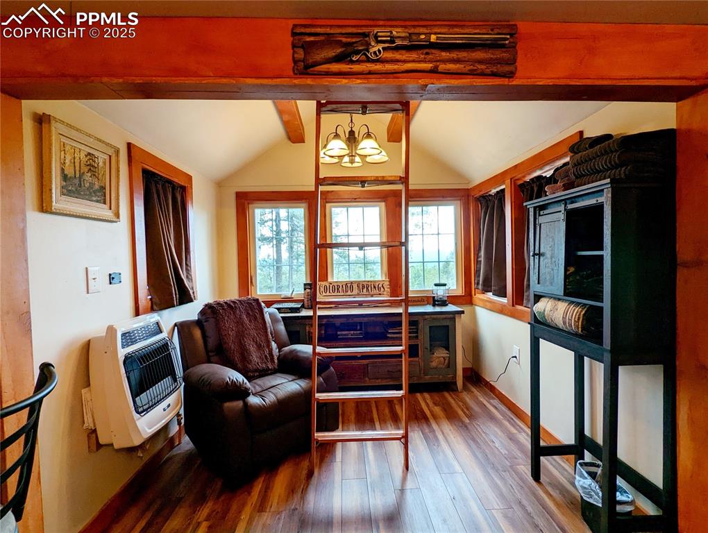 Image 12 of 22: Living area featuring wood finished floors and heating unit