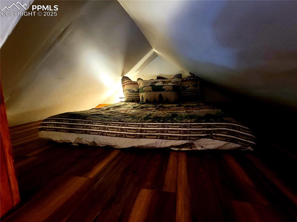 Image 18 of 22: Stairs with wood finished floors and lofted ceiling