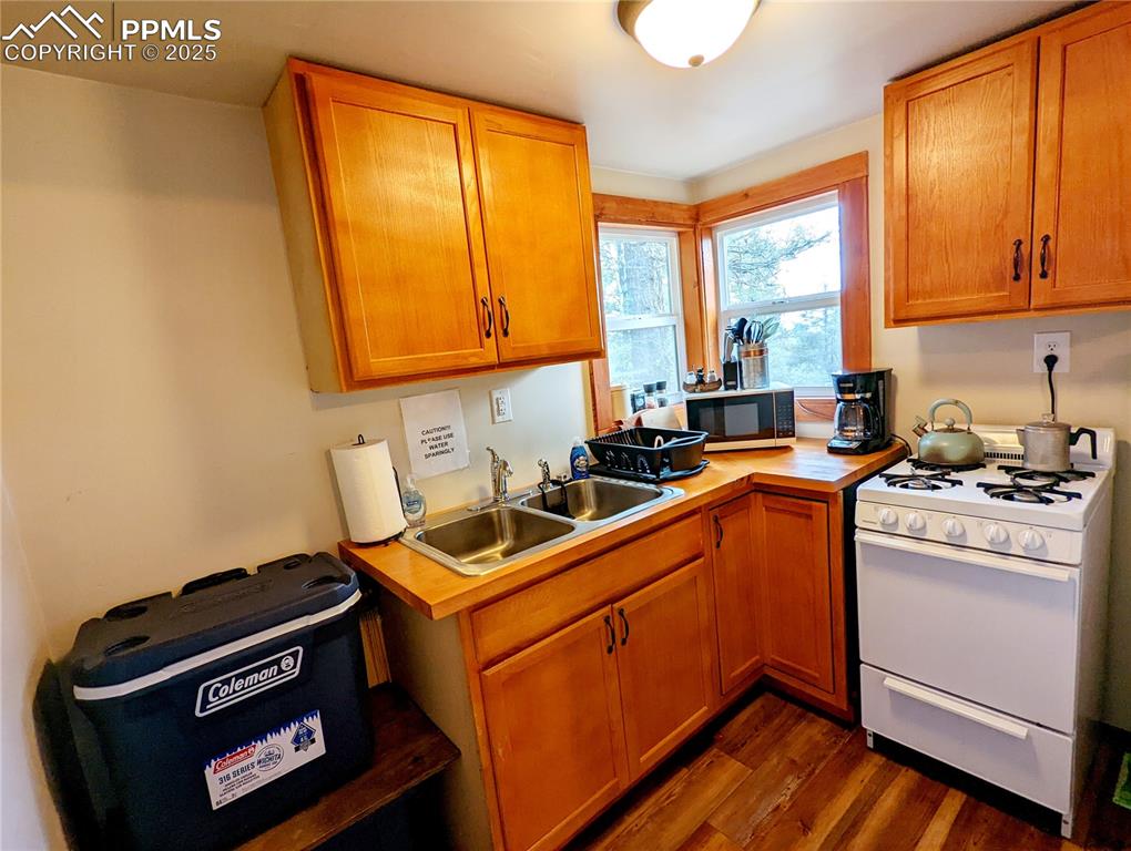 Image 19 of 22: Kitchen featuring white range with gas stovetop, dark wood finished floors,