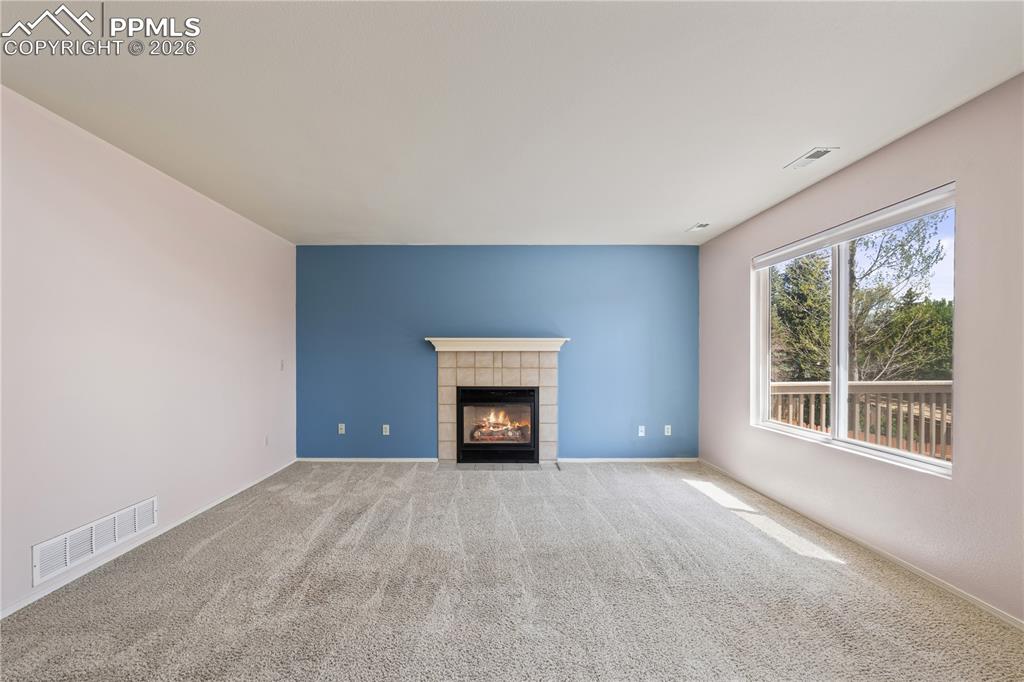 Image 13 of 43: Dining area with hardwood floors, chandelier, large windows and open stairw