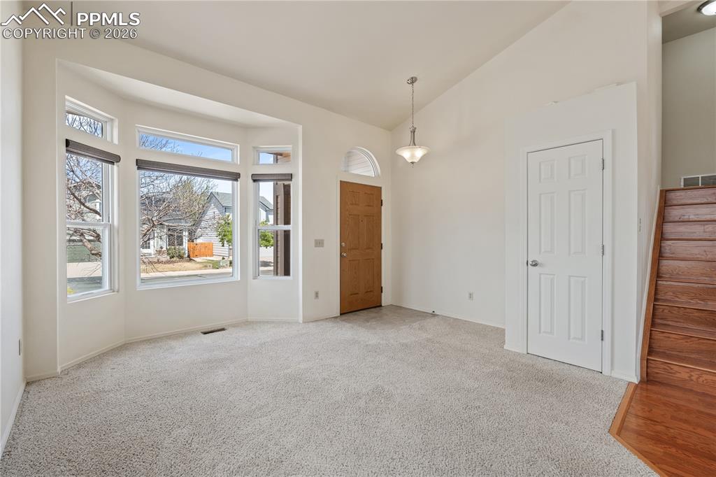 Image 3 of 43: Inviting entry with bright lighting, tile flooring at entry, carpet through