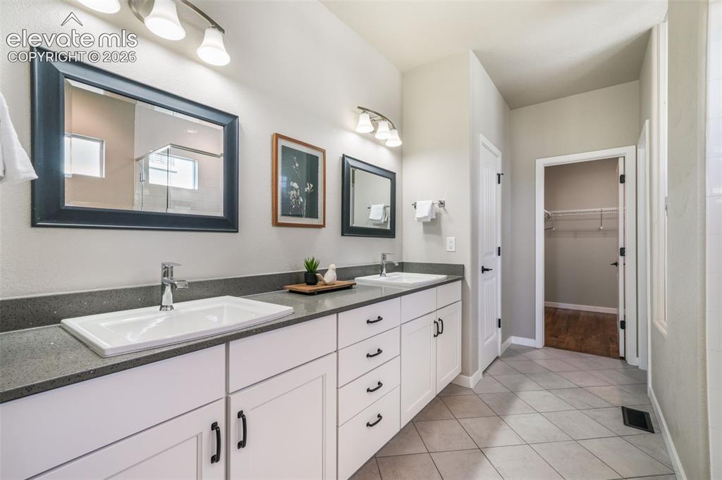 Image 27 of 50: Large walk-in closet, dual sinks, quartz countertops.