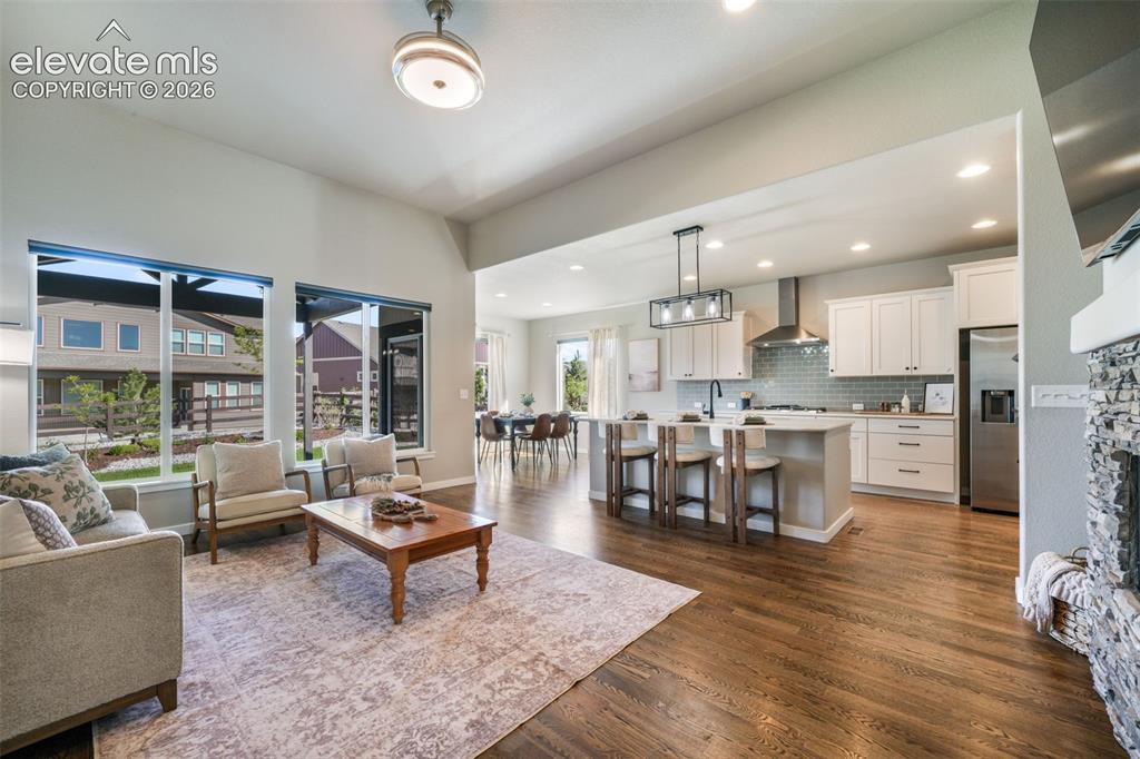 Image 7 of 50: Lots of natural light, hardwood floors, and a built-in gas fireplace.