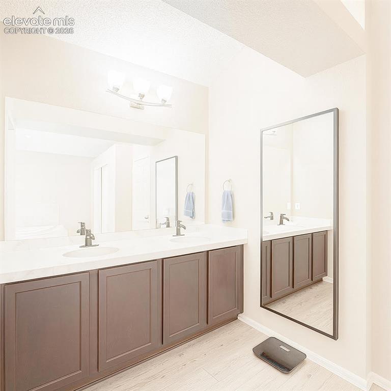 Image 10 of 15: Dual vanity with undermount sinks, single-handle faucets, and dark wood-fin