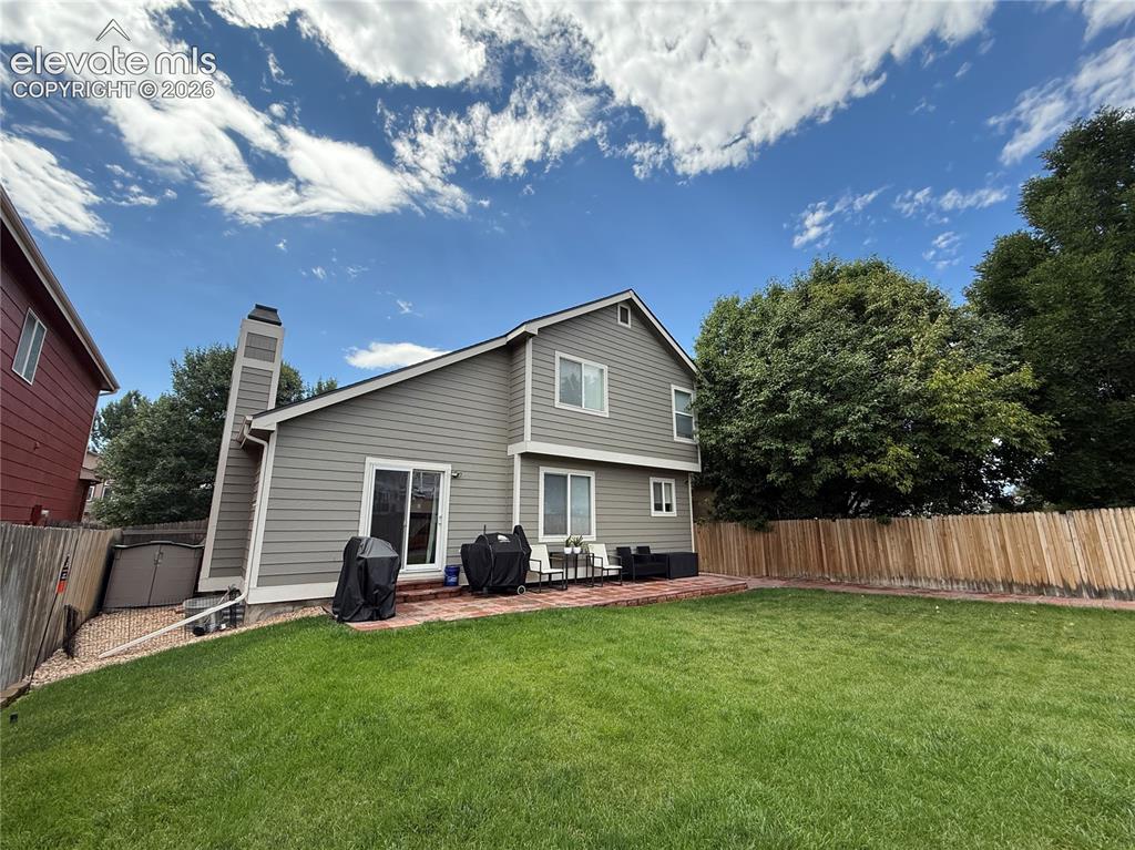 Image 13 of 15: Siding exterior with a brick patio, dual-pane windows, sliding glass door, 