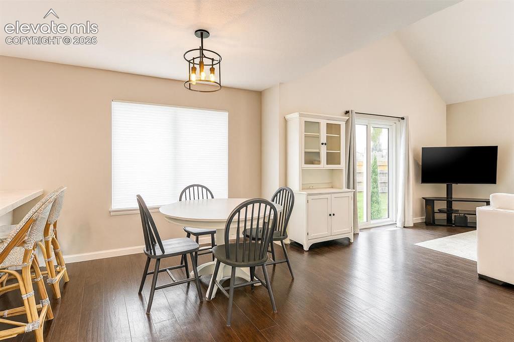 Image 3 of 15: Vaulted ceiling, wood-finish flooring, sliding glass door, and recessed lig