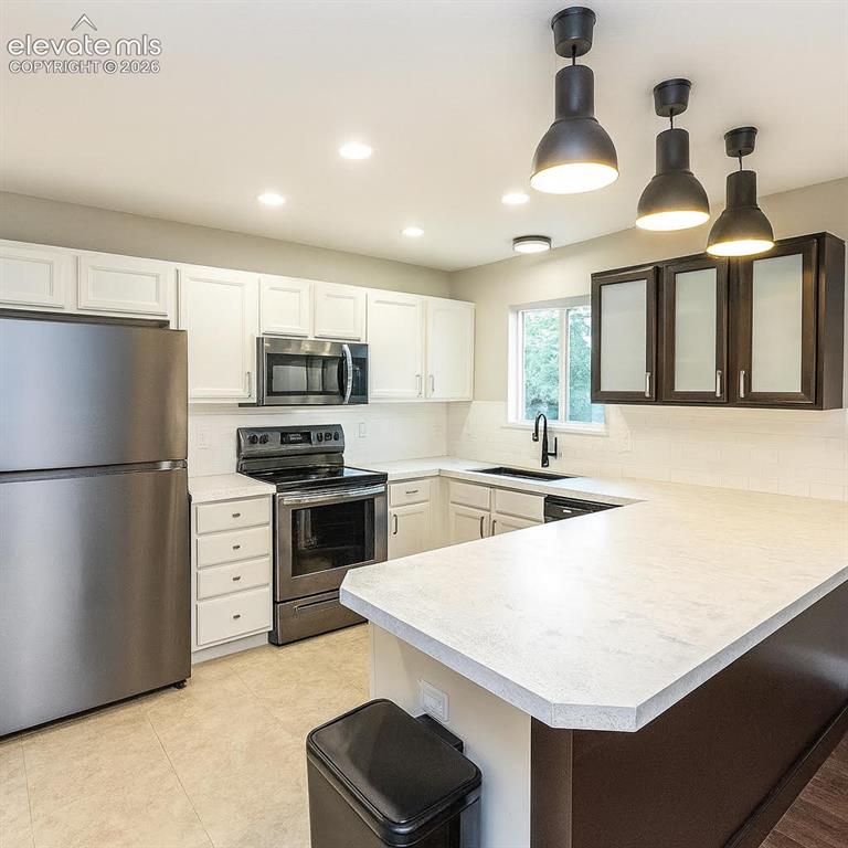 Image 4 of 15: Stainless steel appliances, white cabinetry, dark accent cabinetry with fro