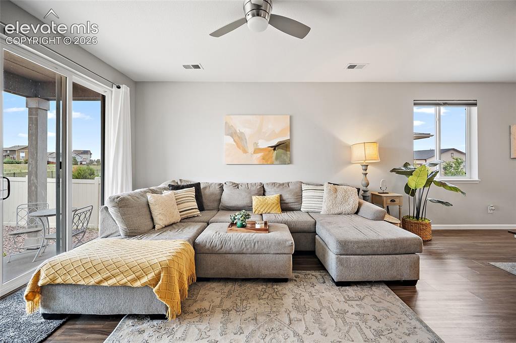 Image 10 of 38: Living area featuring wood-finish flooring, a contemporary ceiling fan, and