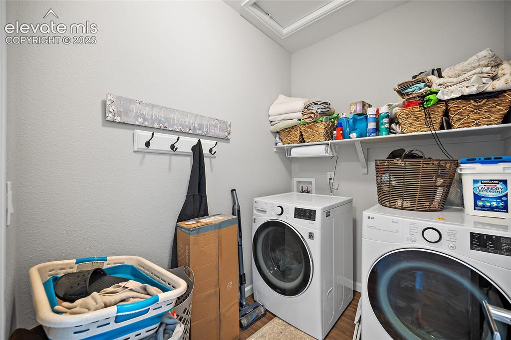 Image 13 of 38: Laundry area featuring wood-finish flooring, light gray walls, and white wa