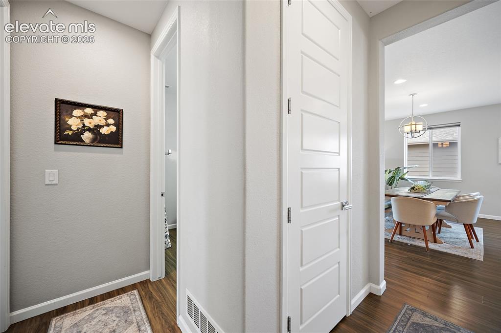 Image 14 of 38: Interior hallway featuring wood-finish flooring, white baseboards, and a wh