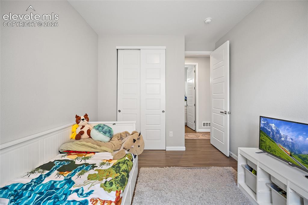 Image 17 of 38: Interior space featuring wood-finish flooring, white paneled doors, and lig