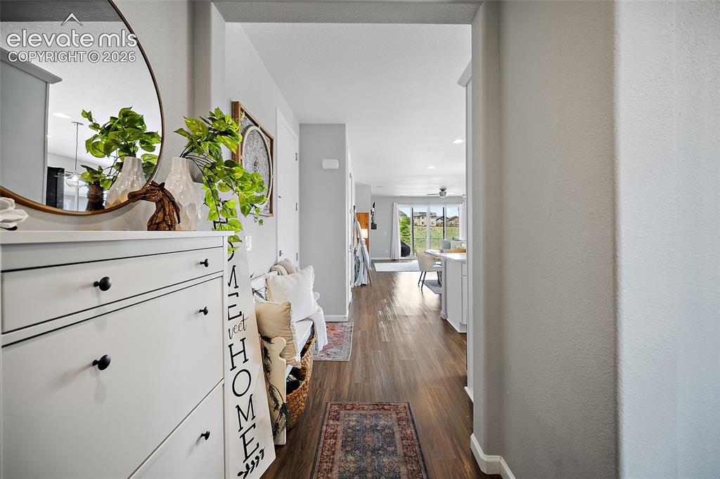 Image 2 of 38: Hallway featuring wood-finish flooring, light gray wall paint, and white ba