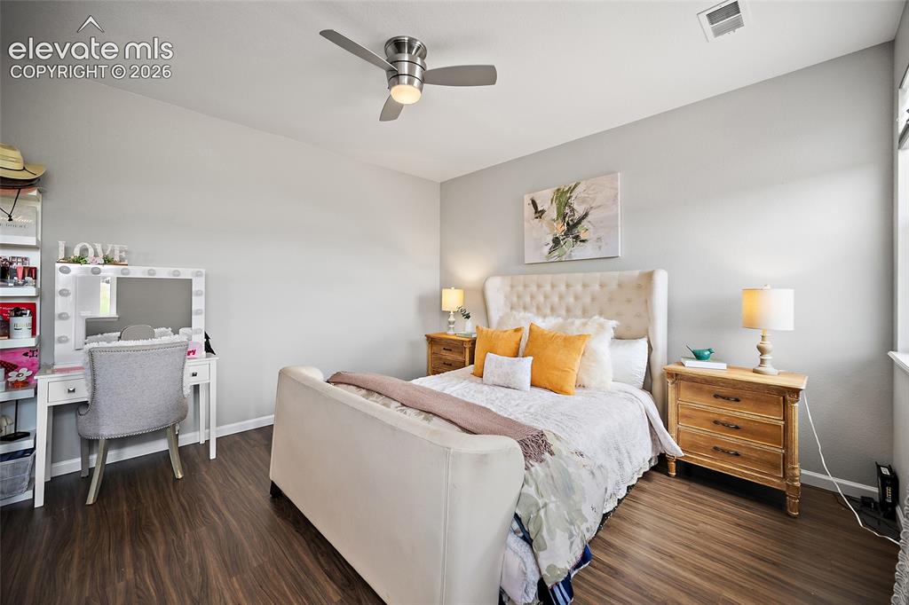 Image 20 of 38: Spacious bedroom featuring wood-finish flooring, a contemporary ceiling fan