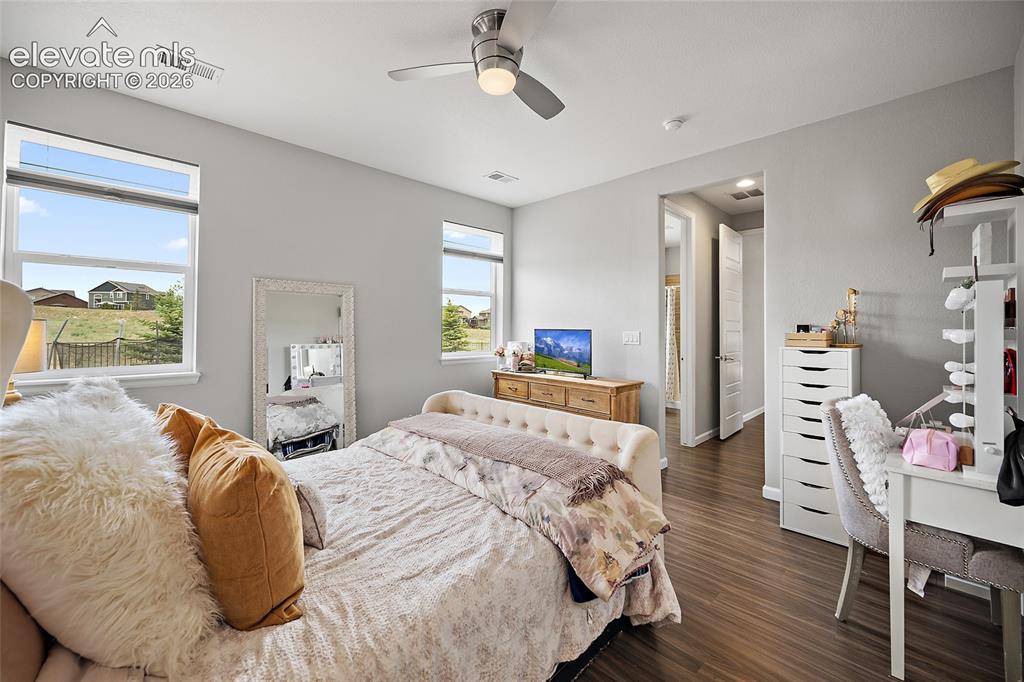 Image 21 of 38: Spacious room featuring multiple windows, wood-finish flooring, a ceiling f
