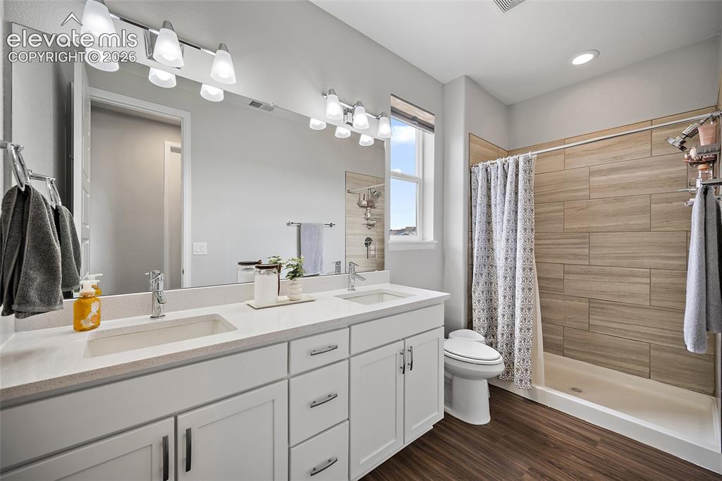 Image 22 of 38: Bathroom featuring a dual vanity with undermount sinks and light-toned coun