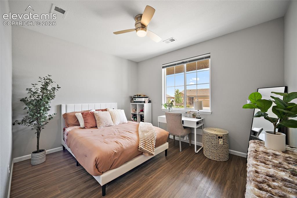 Image 23 of 38: Bedroom featuring wood-finish flooring, a contemporary ceiling fan with int