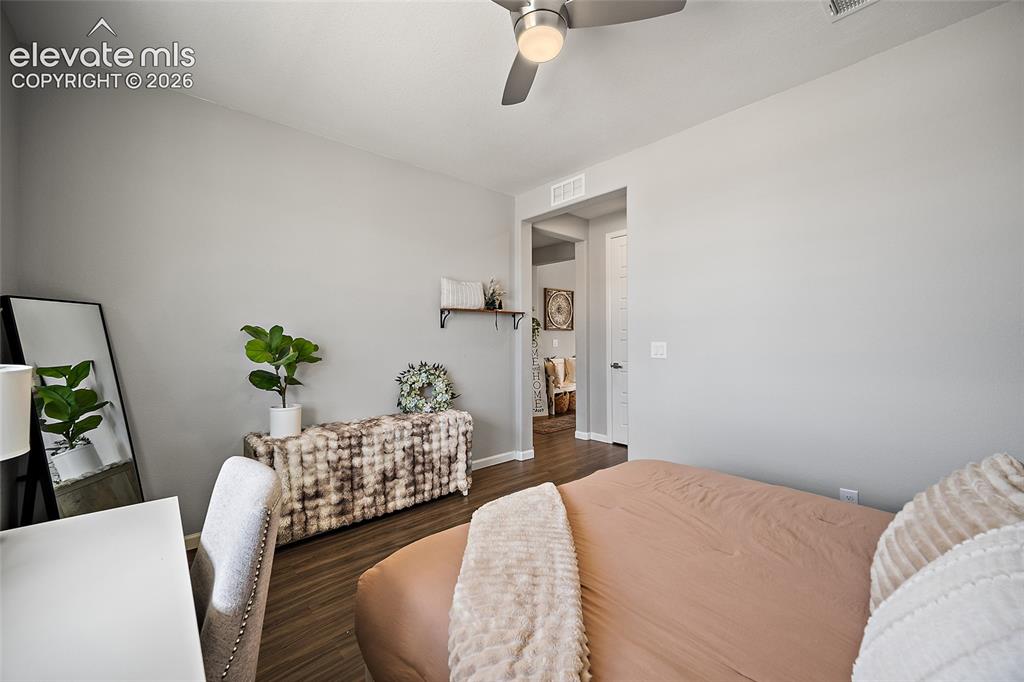 Image 24 of 38: Neutral-toned interior room featuring wood-finish flooring, a ceiling fan w