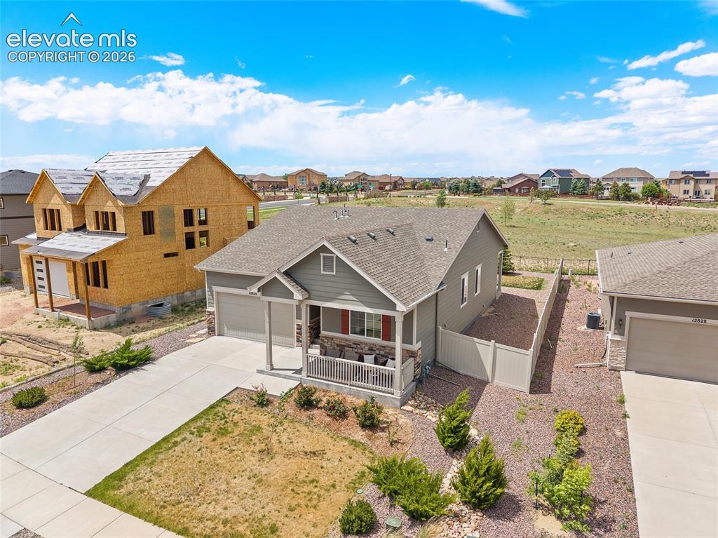 Image 29 of 38: Single-story residence featuring a covered front porch with stone accents,