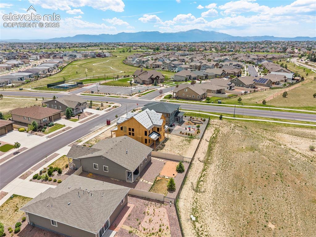 Image 35 of 38: Expansive lot with a mountain backdrop, featuring a partially built home, a