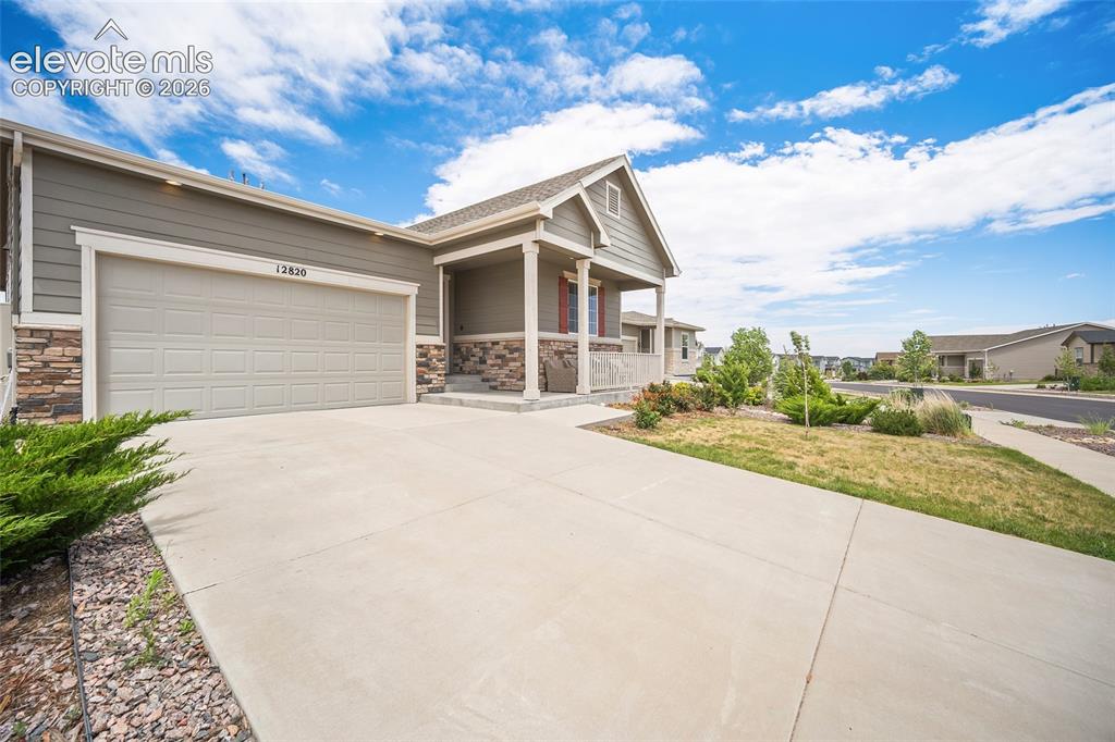 Image 37 of 38: Ranch-style exterior featuring horizontal siding, stone veneer accents, an
