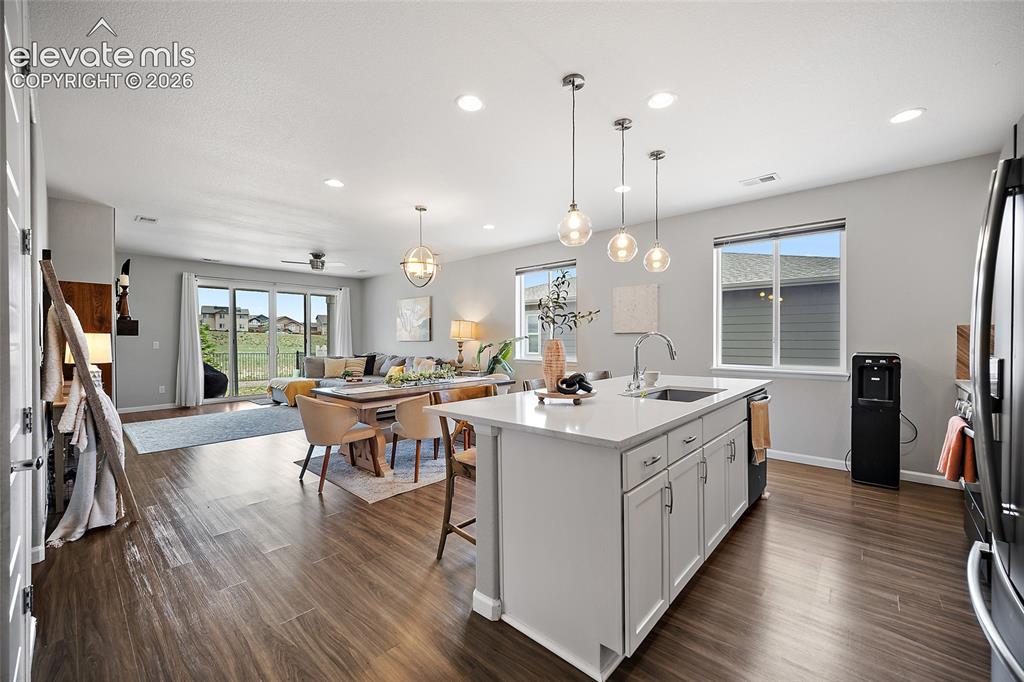Image 6 of 38: Open-concept living space featuring wood-finish flooring, a kitchen island