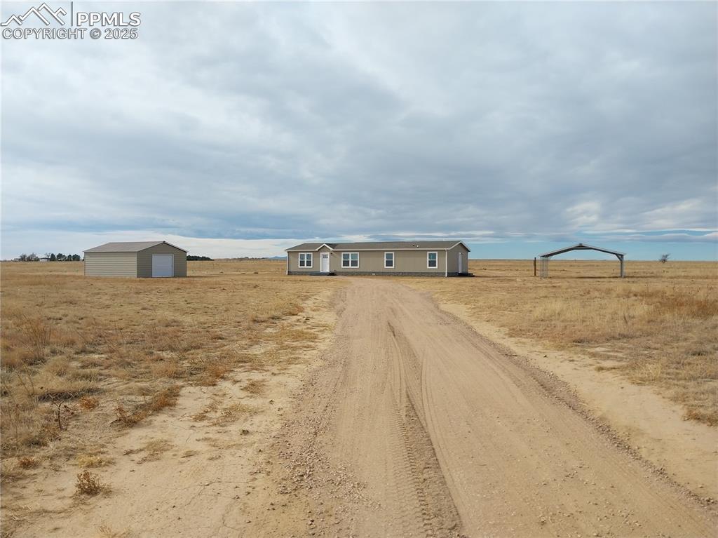 Caption: View of dirt / gravel road featuring a view of rural / pastoral area