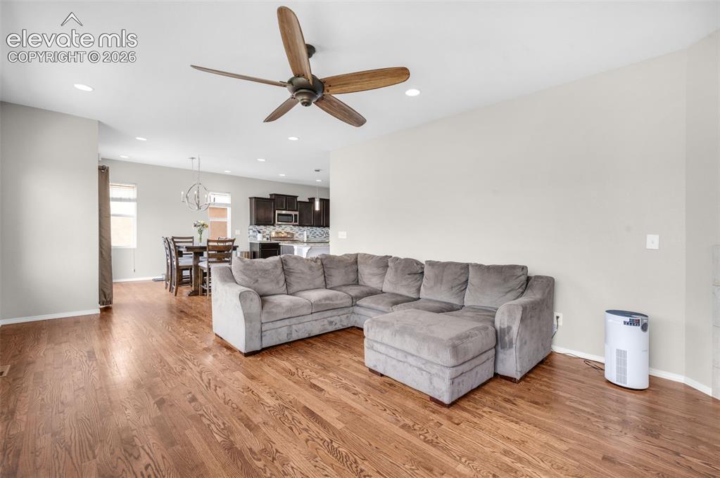 Image 11 of 34: Expansive living area featuring wood-finish flooring, recessed lighting, an