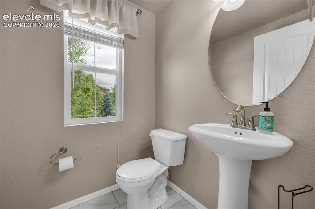 Image 13 of 34: Powder room featuring a pedestal sink with brushed nickel faucet, a rounded