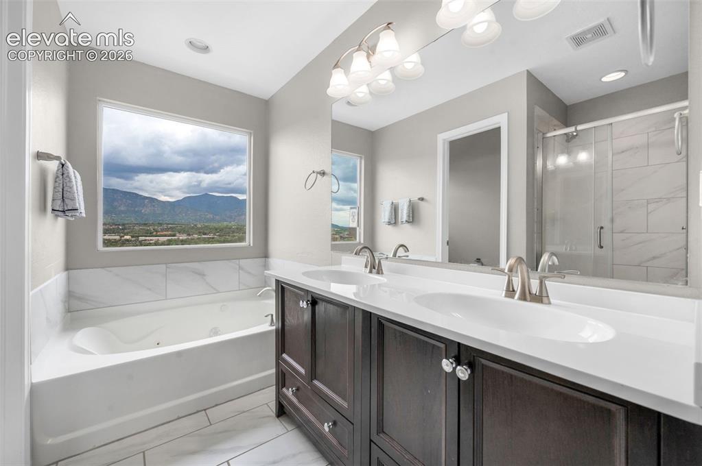 Image 16 of 34: Primary bathroom with a soaking tub, seperate shower, double vanities, and