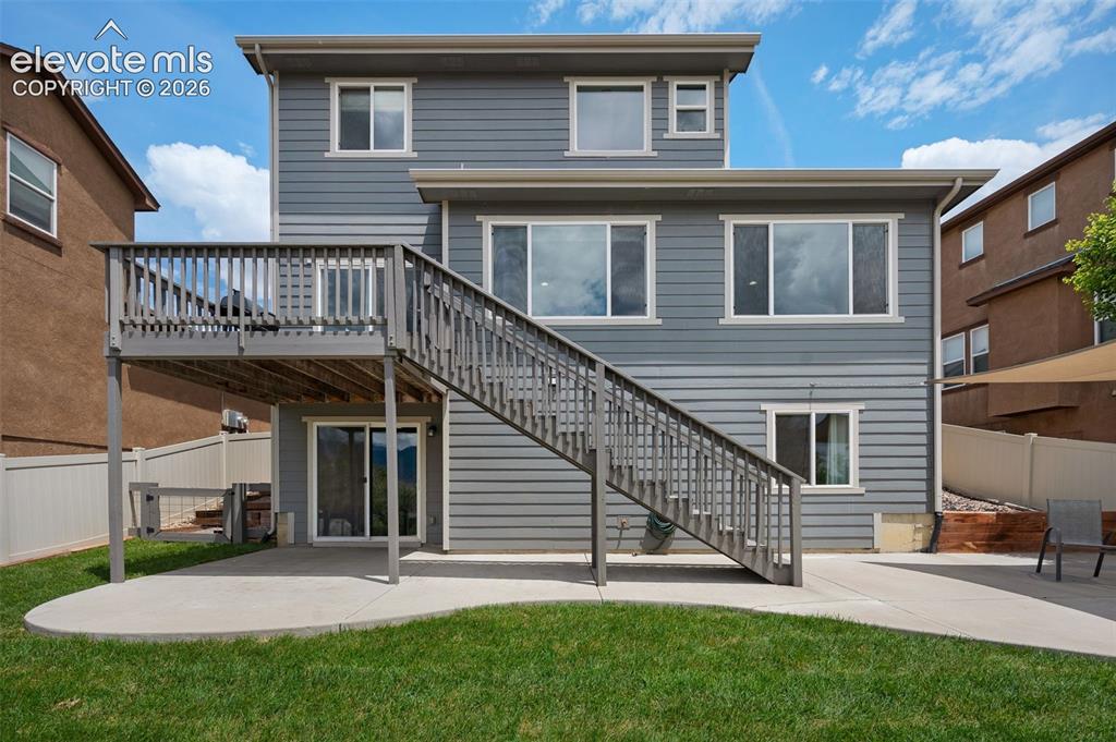 Image 2 of 34: Rear exterior featuring multi-level grey siding, an elevated wood deck with