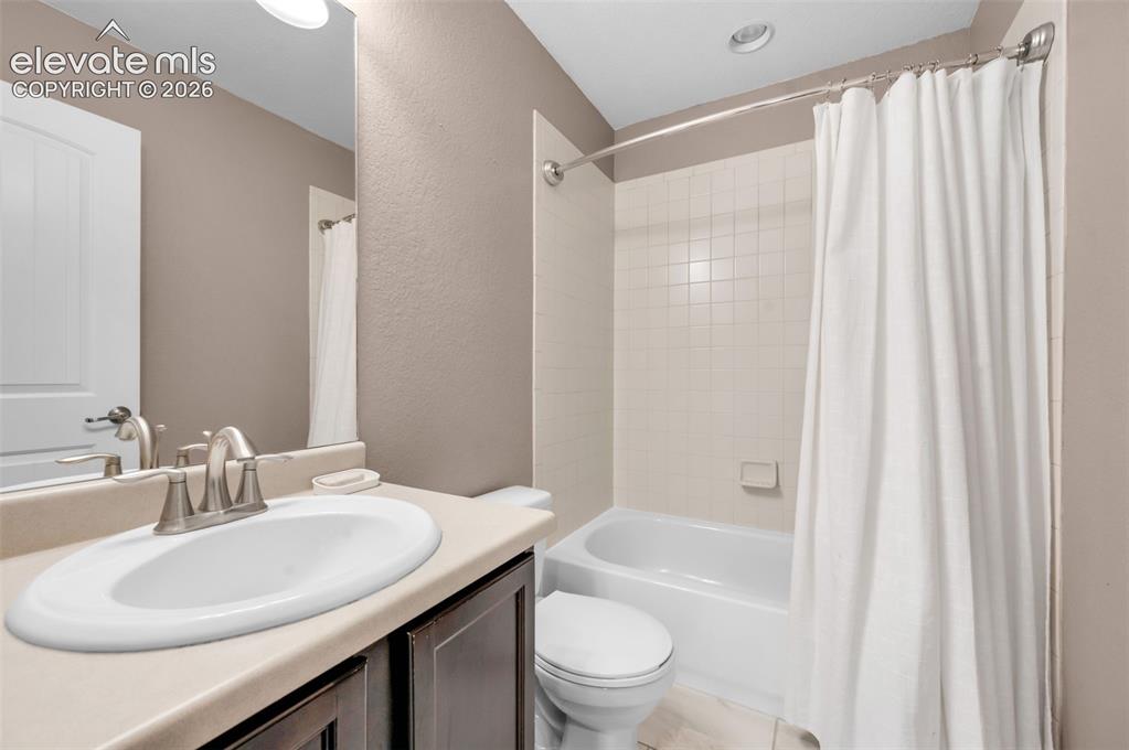 Image 20 of 34: Upstairs hall bathroom featuring a vanity with a drop-in sink, brushed nick