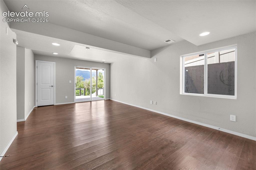Image 22 of 34: Spacious Rec Room interior featuring wood-finish flooring, recessed lightin