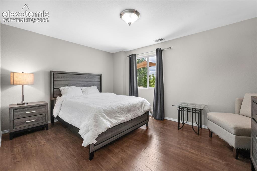 Image 25 of 34: Bedroom #4 Spacious room featuring wood-finish flooring, a large window wit