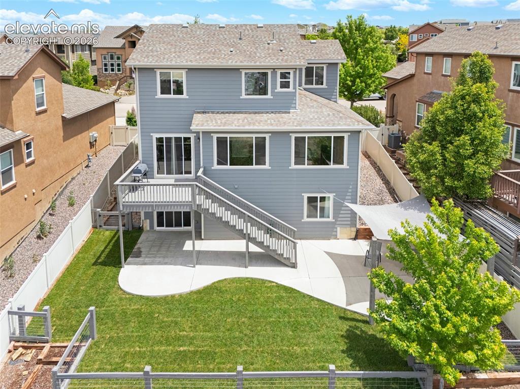 Image 29 of 34: Rear exterior featuring a multi-level deck, a concrete patio, and a manicur