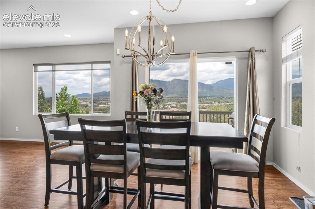 Image 8 of 34: Dining area with wood-finish flooring, recessed lighting, and a contemporar