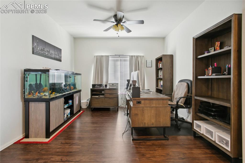 Image 17 of 49: Home office with baseboards, a ceiling fan, and dark wood-style flooring