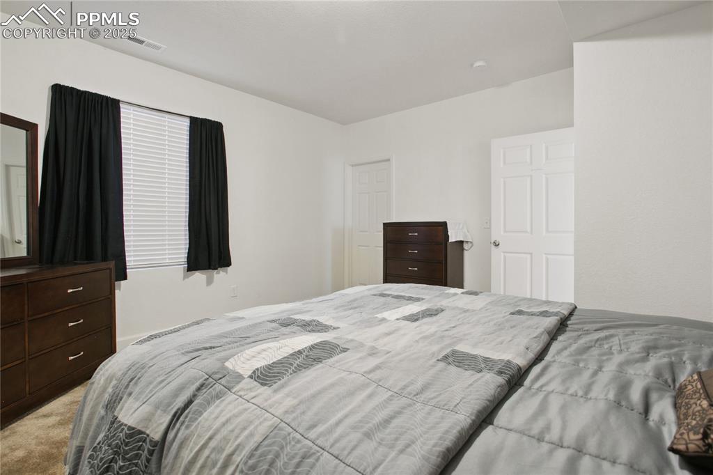 Image 33 of 49: Bedroom featuring visible vents and light colored carpet