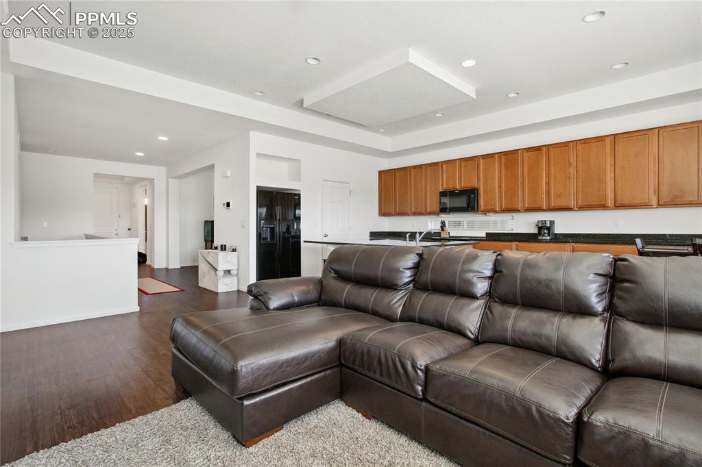 Image 6 of 49: Living room with dark wood-type flooring and recessed lighting